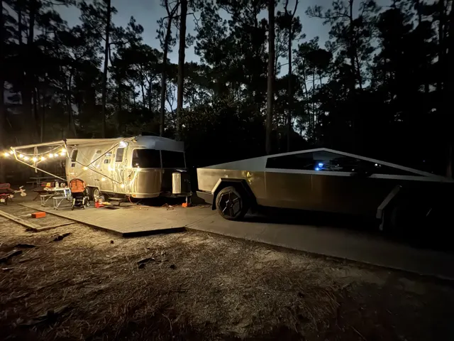 Travel trailer: Evening camp under the pines with string lights